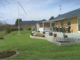 Have med terrassebelægning og støttemur til bed